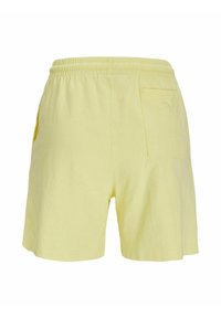Pantalones cortos de algodón amarillos con cinturilla elástica, que cuentan con bolsillos laterales y un bolsillo en la parte trasera. Textura suave, corte holgado, longitud hasta mitad del muslo.