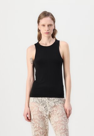 Svart ermeløs tanktop laget av glatt stoff, med rund halsringning og en tettsittende design. Kombinert med gjennomsiktige blonderbukser.