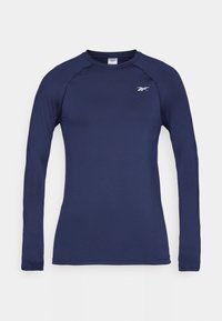 Tricou sportiv cu mânecă lungă de culoare bleumarin, fabricat dintr-un material neted și respirabil. Are un guler rotund și un mic logo alb pe partea superioară stângă a pieptului.