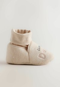Beige soft baby bootie with folded cuff and embroidered text on the front, designed for comfort and warmth.