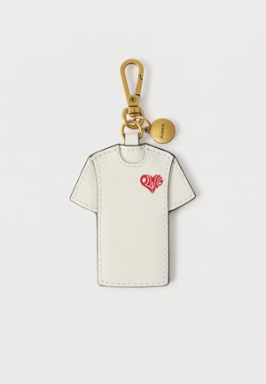 Schlüsselanhänger aus weißem Leder in T-Shirt-Form mit rotem Herzmotiv und goldfarbenem Verschluss, versehen mit einer runden goldfarbenen Plakette, auf der "PINKO" eingraviert ist.