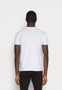 Weißes Baumwoll-T-Shirt mit rundem Halsausschnitt und kurzen Ärmeln, bietet eine glatte Textur und eine lockere Passform. Keine sichtbaren Logos oder Muster.
