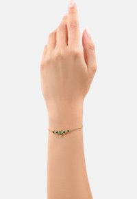 Pulsera de tono dorado con piedras preciosas verdes alternadas en forma rectangular y redonda. Diseño de cadena delicado, adecuado para uso casual o formal.