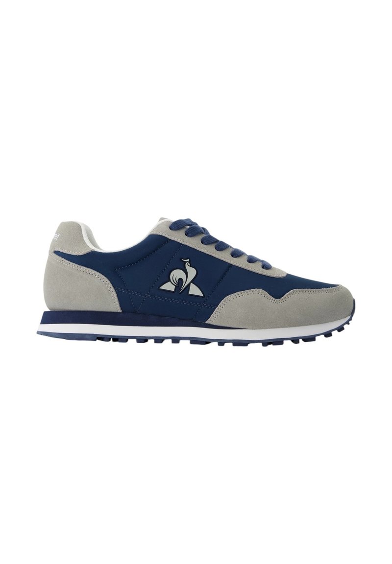 Zapatillas para hombre con una parte superior de tela en color azul marino y acentos de ante gris, con una suela de goma blanca, cordones redondos y un logo en el lado.