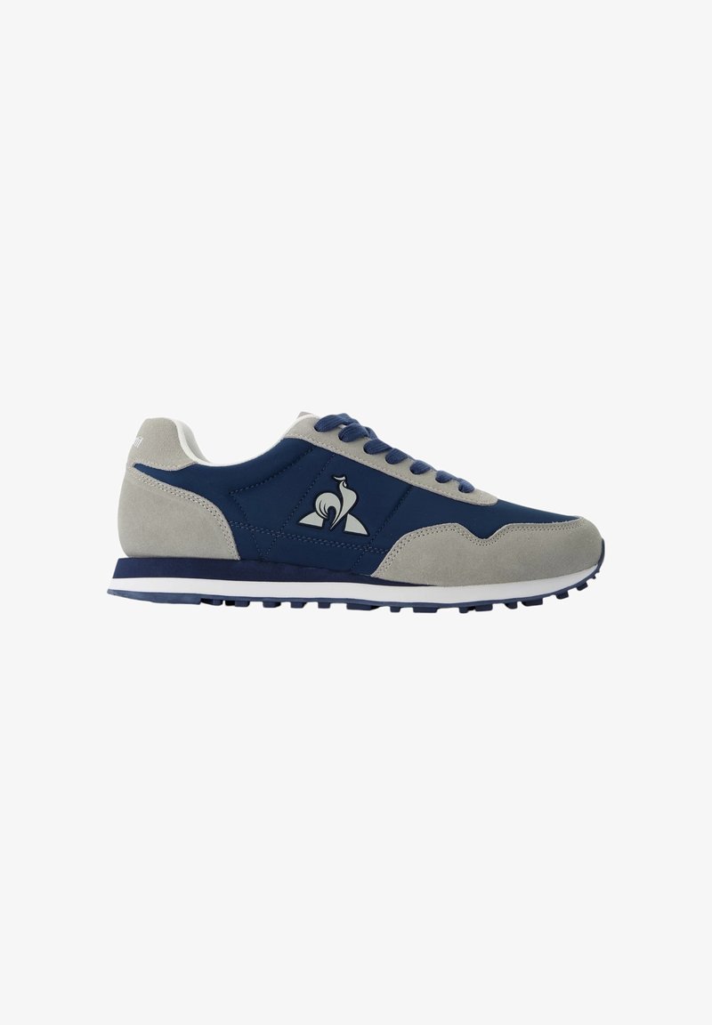 Heren sneakers met een marineblauwe stoffen bovenkant en grijze suède accenten, voorzien van een witte rubberen zool, ronde veters en een logo aan de zijkant.