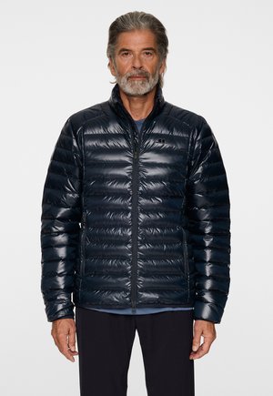 Mørkeblå pufferjakke med en shiny finish, quiltet design, høj krave, frontlynlås og raglanærmer. Velegnet til udendørsbrug.