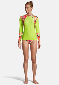 Rash guard à manches longues de couleur vert lime vif avec des accents floraux en rose, orange et violet. Accompagné d'un bas de bikini assorti.