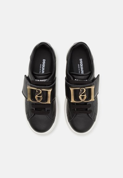 Sneaker nere in pelle con punta arrotondata, fibbia dorata, strap in Velcro e suola in gomma bianca. Marchio visibile all'interno.