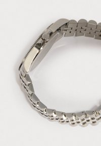 Ασημένιο ρολόι από ανοξείδωτο ατσάλι με λεία θήκη, υφή περιθωρίου και βραχιόλι από συνδέσμους με γυαλιστερό φινίρισμα και στρογγυλεμένες άκρες.