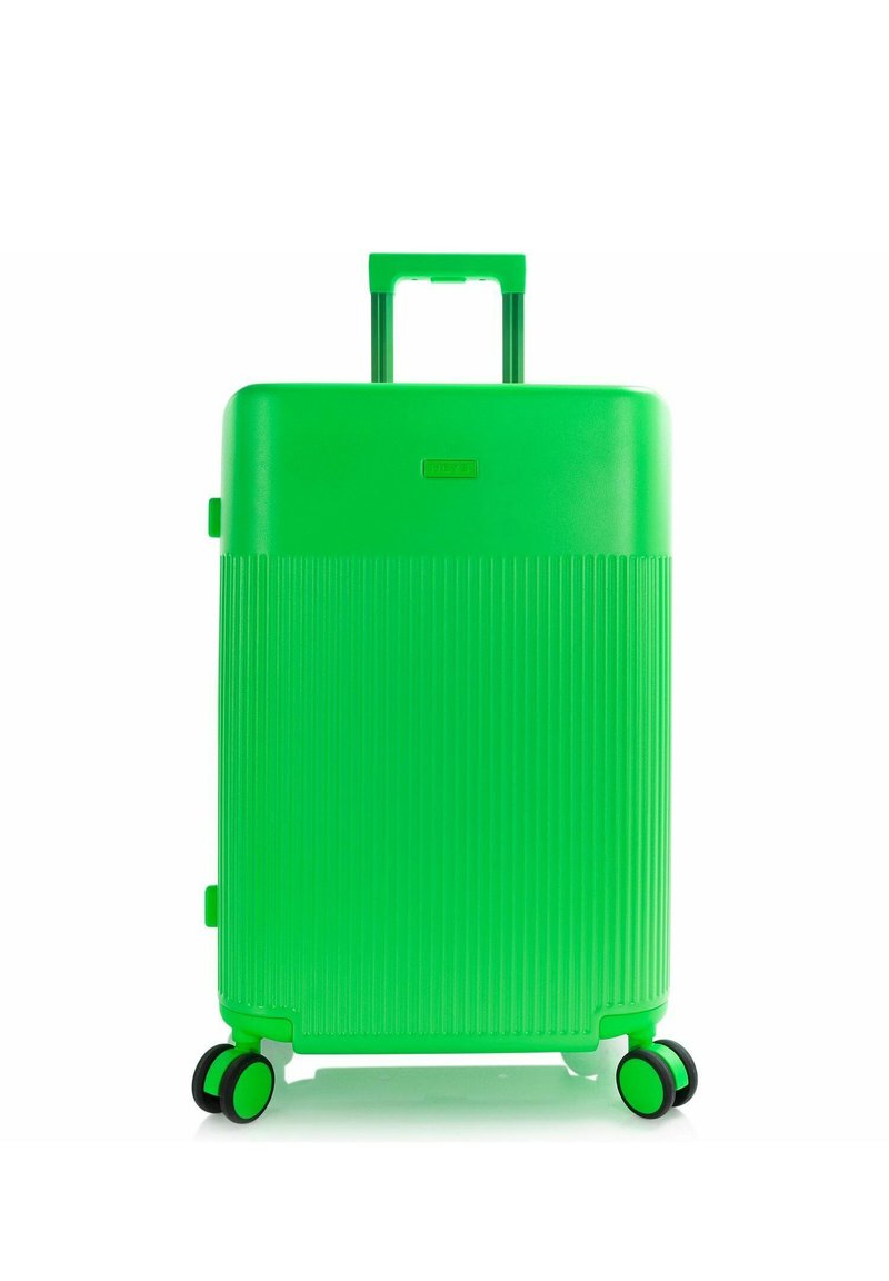 Valise rigide verte éclatante avec des rainures verticales, quatre roues doubles et une poignée télescopique prolongée.