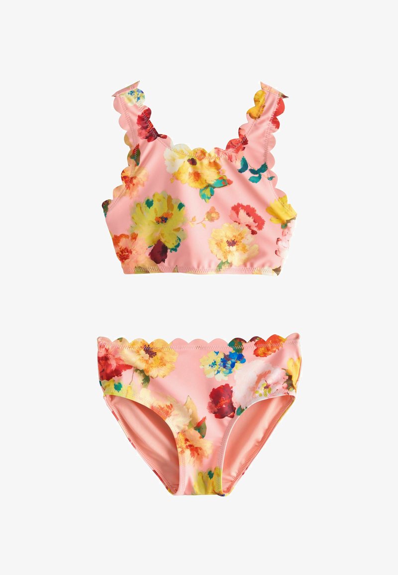 Maillot de bain deux pièces rose à motifs floraux avec bords festonnés en haut et en bas, avec de grandes impressions de fleurs jaunes, rouges et bleues.