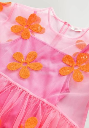 Vaaleanpunainen mekko, jossa on läpikuultava päällyskerros ja oranssit paljetti-kukat. Mekossa on kerrottu helma ja pyöreä kaula-aukko. Takana vetoketjukiinnitys.