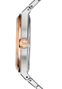 Montre en acier inoxydable avec une lunette en or rose, une couronne texturée et un bracelet en métal lisse. Présente une forme rectangulaire élégante.