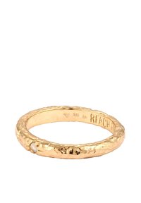 Prsten zlatne nijanse s teksturom koji sadrži mali prozirni kamen, s zakovanim završetkom i glatkom unutrašnjošću, označen s '925' i 'RFACH'.