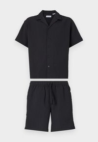 Sort kortærmet skjorte med knapfront og ribbet struktur, parret med matchende sorte shorts med elastisk talje og snøre.