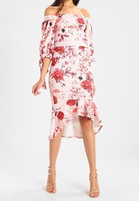 Sukienka bez ramiączek w jasnoróżowym kolorze, zdobiona czerwonymi różami i czarnymi akcentami. Dopasowany krój z falbankowym dołem i detalami rękawów.