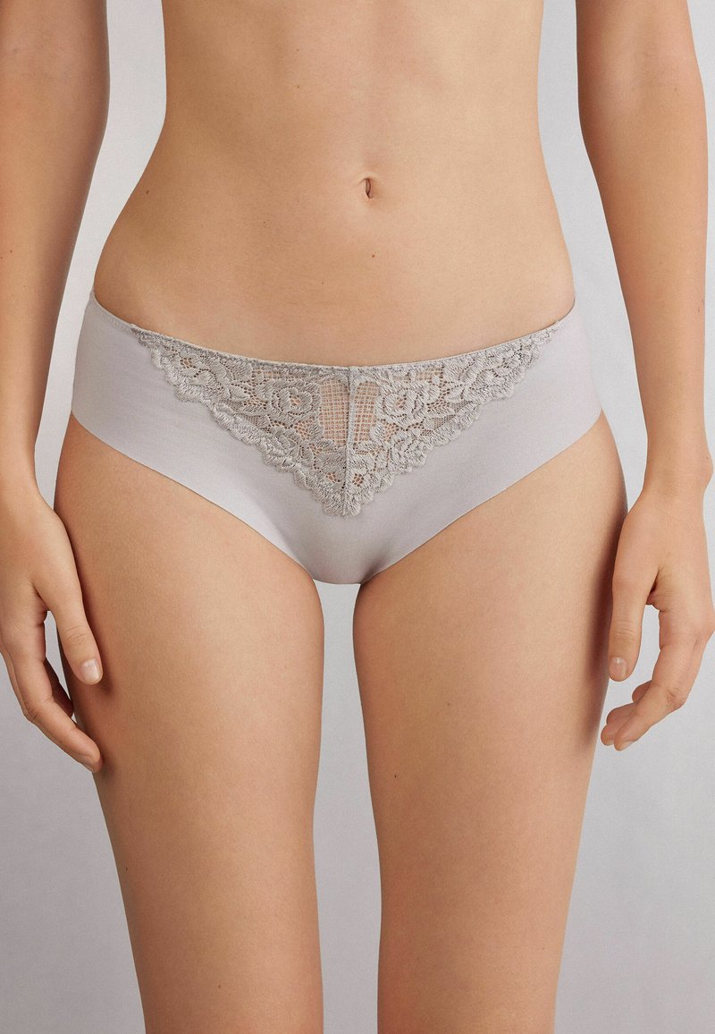 Ljusgrå kvinnors bomullsunderkläder med spetsdetaljer fram, en klassisk skärning och en mjuk textur. Inga ytterligare mönster eller accenter.