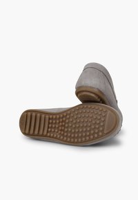 Šedá semišová nazouvací bota s texturovanou gumovou podrážkou, která má vyvýšené tečky a drážky pro lepší trakci. Hladký povrch a minimální designové detaily.