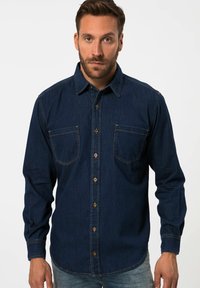 Donkerblauwe denim shirt met een puntkraag, twee borstzakken en knoopsluiting. Heeft contrasterende stiksels en lange mouwen.