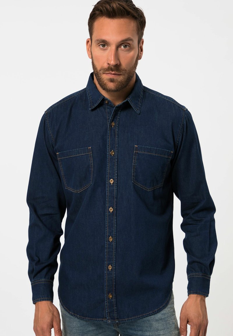 Donkerblauwe denim shirt met een puntkraag, twee borstzakken en knoopsluiting. Heeft contrasterende stiksels en lange mouwen.
