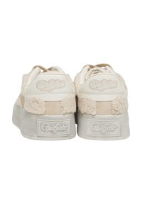 Paire de baskets crème de la marque Buffalo avec des semelles épaisses et un tissu texturé et duveteux à l’arrière et au niveau du talon.