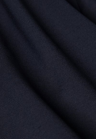Tissu bleu marine foncé avec une fine texture côtelée, présenté en plis doux mettant en valeur le matériau lisse et finement tricoté.