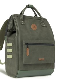 Sac à dos olive en vert avec une surface texturée, des accents en cuir, des poignées supérieures, une poche zippée à l'avant, et des sangles en toile sur les côtés pour des accessoires.
