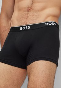 Black boxer briefs featuring a comfortable elastic waistband with the "BOSS" logo in white. Made from a soft, stretchy material.