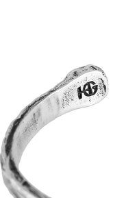 Silver snake-shaped bracelet with a textured surface and a subtle engraved logo. Curved design, polished finish, and open-ended style.