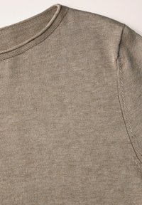 Pull en maille beige clair, doté d'un col rond, d'une texture douce, et de détails de couture subtils le long des épaules.