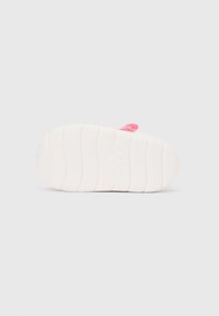 Λευκή σόλα με υφασμάτινες αύλακες και ροζ λουράκι. Το λουράκι έχει λεία υφασμάτινη επιφάνεια και μικρό λογότυπο.