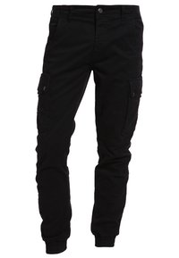Svarta cargo byxor med knappade sidofickor, framfickor och elastiska muddar vid anklarna, visade mot en vit bakgrund.