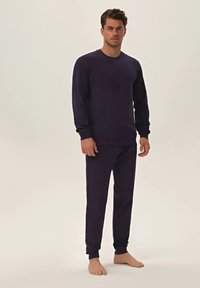 Granatowy zestaw odzieży domowej wykonany z miękkiego materiału; bluza z okrągłym dekoltem i długimi rękawami oraz dopasowane, zwężane spodnie z elastycznymi mankietami.