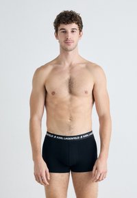 Fekete boxer nadrág logós derékrésszel, amelyen a "KARL LAGERFELD" felirat található. Puha anyagból készült, testhezálló fazonnal és minimalista stílusban.