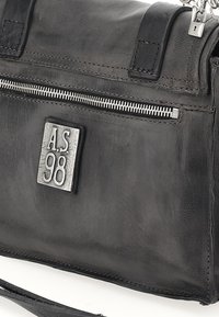 Zwarte leren handtas met een gestructureerde afwerking, ritsvak en gegraveerd "A.S. 98" plaatje. Voorzien van stevige handvaten en een afneembare schouderband.