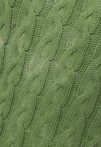 Groene gebreide stof met een gestructureerd kabelpatroon en verweven vlechten, die verschillende tinten groen benadrukt.