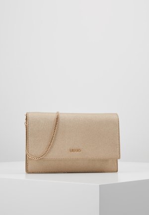 Beżowa teksturowana kopertówka z złotym łańcuszkiem i logo LIU JO, umieszczona na białym piedestale na jednolitym szarym tle.