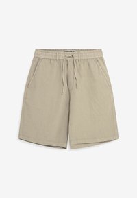Shorts en lin beige avec une taille élastique, un cordon de serrage et des poches latérales. Le tissu a une texture lisse et une coupe décontractée.