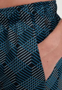 Black fabric shorts featuring a geometric pattern of blue and white diagonal lines. Elastic waistband with a side pocket.
