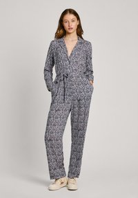 Jumpsuit z cvetnim vzorcem v mornarsko modri barvi z dolgimi rokavi, ovratnikom in pasom; ima stranska žepa in sproščen kroj.