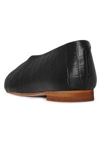 Juodos odinės plokštelės su krokodilo odos raštu, lygus medinis kulnas ir elegantiškas, minimalistinis dizainas.