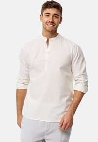 Lightweight white button-up shirt with a mandarin collar, long roll-up sleeves, and a textured fabric. Suitable for casual wear.