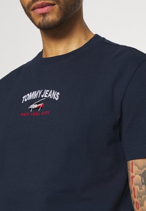 Navy blue short-sleeve T-shirt made of cotton, featuring embroidered "TOMMY JEANS" and "NEW YORK CITY" in white and red on the front.