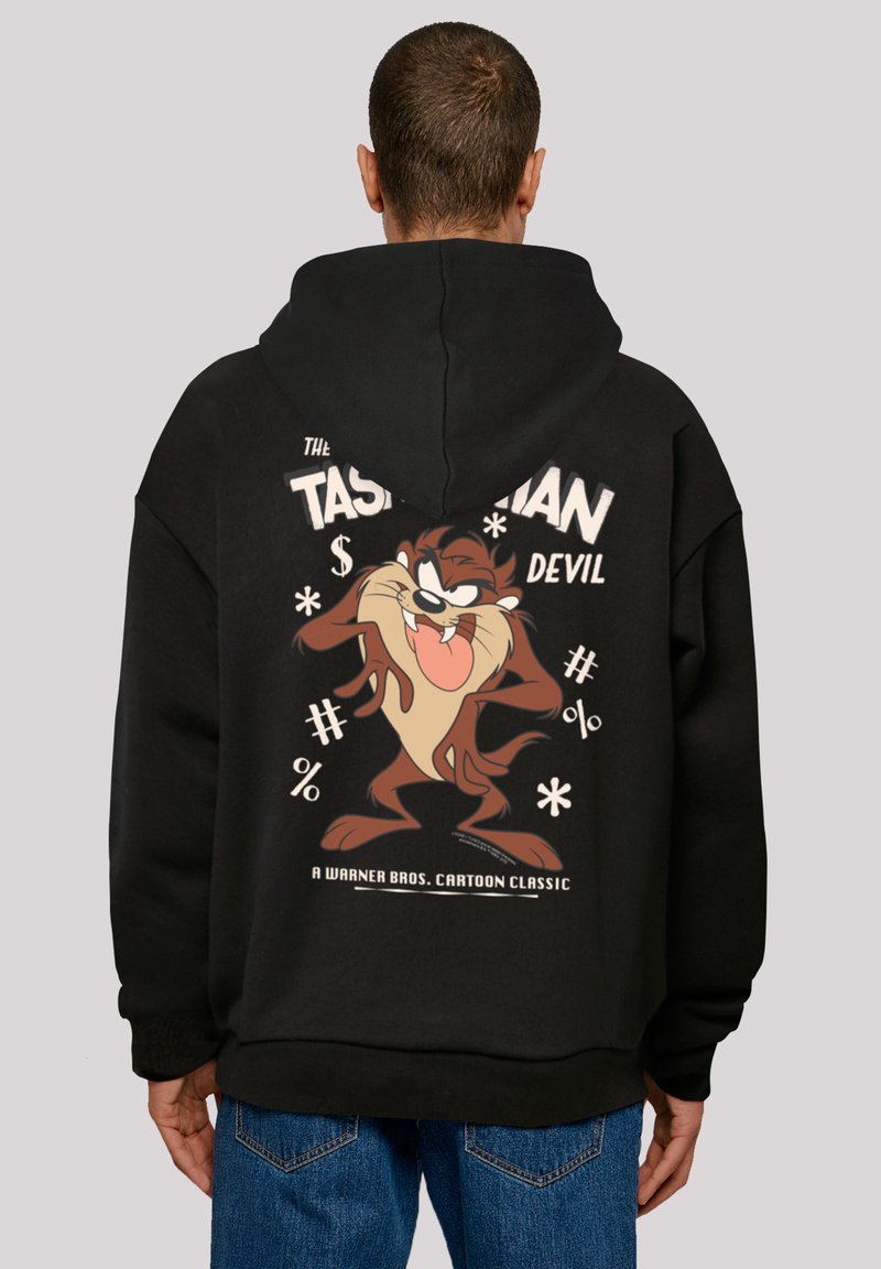 Svart hettegenser med et stort tegneseriegraphic av Tasmanian Devil på baksiden, med tykk tekst og lekne symboler i lyse farger.