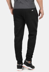 Zwarte katoen sweatpants met een elastische tailleband en zijzak, met een tapered leg ontwerp en ribgebreide boorden. Casual sportief schoeisel.