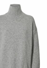Sivi pulover s visokim ovratnikom napravljen od mekog pletenog materijala. Ima rebrasti ovratnik i široke rukave, s glatkom, ujednačenom teksturom kroz cijeli pulover.