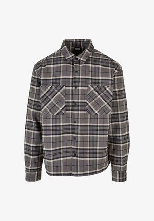 Chemise à carreaux gris en tissu présentant des motifs en check noir et blanc. Dotée de manches longues, d'une fermeture à boutons à l'avant et de deux poches sur la poitrine.