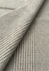 Tessuto di lana in beige chiaro con un motivo a quadri texture e linee sottili. Superficie morbida, leggermente testurizzata, con strati sovrapposti.