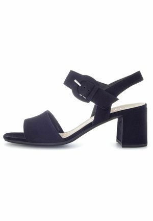 Sandales à talons en daim noir avec un bout ouvert, une large bande sur le devant, une bride de cheville réglable avec boucle et un talon carré.