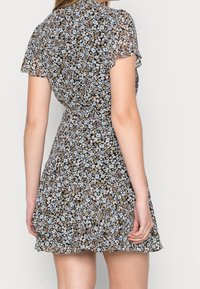 Blumenkleid mit kurzen Ärmeln, schwarzem Grund und blauen sowie beigen Blumenmustern. Hat eine taillierte Taille und einen ausgestellten Rock.